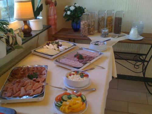 a buffet of food on a table with plates of food at Hotel Reinhold in Gummersbach