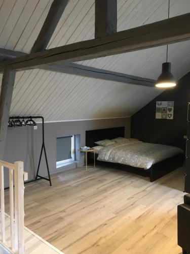 a large room with a bed in a attic at The Cottage and The Loft in Amblève