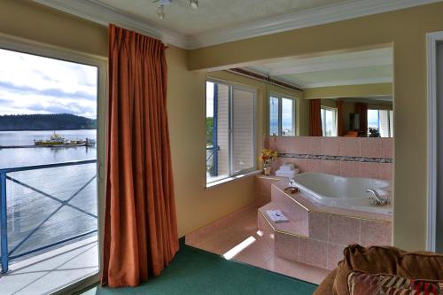 a bathroom with a tub and a large window at Glen Lyon Inn in Port Hardy