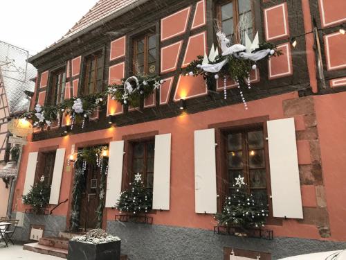a building with christmas trees in front of it at Auberge Le Meisenberg in Châtenois
