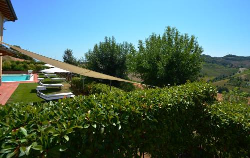 a resort with a pool and some chairs and trees at Locanda Gli Ulivi in Monteveglio