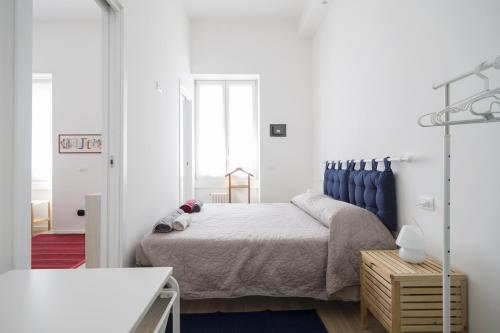 a bedroom with a bed with a blue headboard at PrimoPiano - Astolfo 12 in Milan
