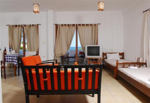 a living room with a couch and a television at Athina Villas in Elounda