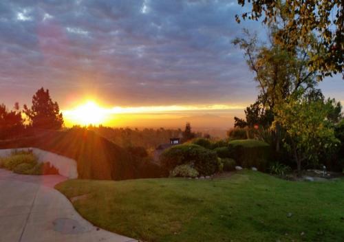 a sunset over a yard with a driveway at The Patrician Hollywood Universal in Pasadena