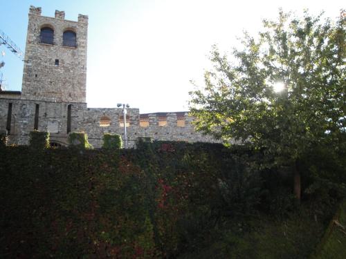 a building with a tower with a tree in front of it at The Tower Of The Old King in Desenzano del Garda