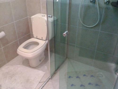 a bathroom with a toilet and a glass shower at Casa Baia da Babitonga in São Francisco do Sul