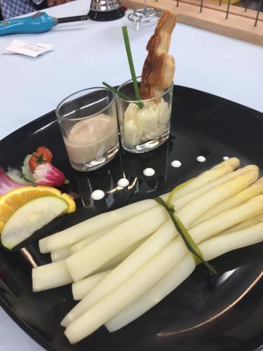 a black plate with celery and two glasses of water at Auberge Le Meisenberg in Châtenois