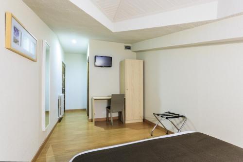 a bedroom with a bed and a desk with a television at Los Guardeses in Solares