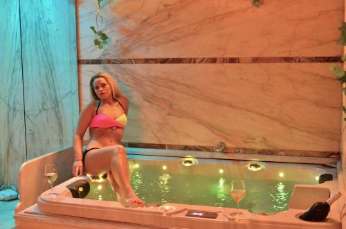 a woman in a bikini sitting in a bathtub at B&B Al Cristo in SantʼAmbrogio di Valpolicella
