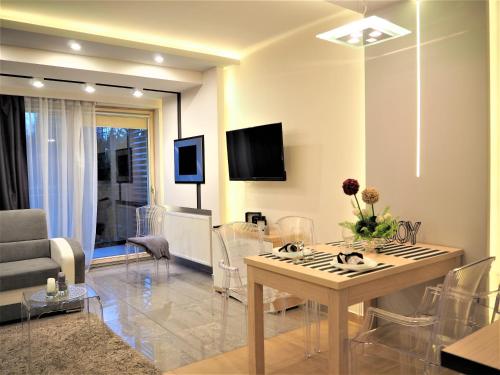 a living room with a table and chairs and a tv at VIP Apartamenty Stara Polana 2 in Zakopane