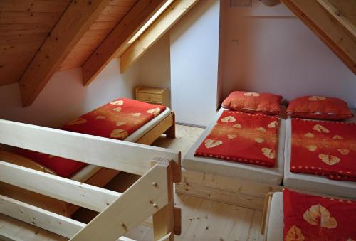 a room with three bunk beds in a attic at U jezera Laka in Prášily