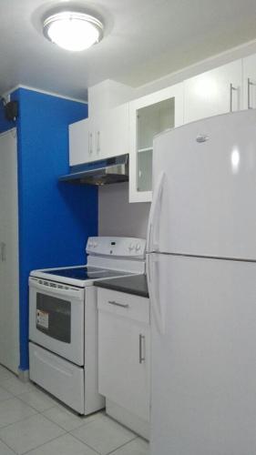 cocina con nevera blanca y armarios blancos en Condominios La Ronda en Tegucigalpa