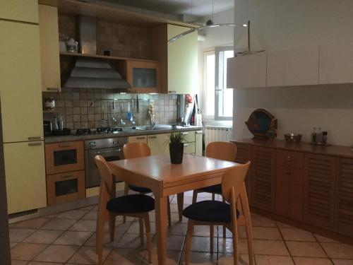 a kitchen with a wooden table and chairs at Il ponticello in Ortona