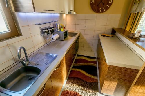 a small kitchen with a sink and a clock on the wall at Nina in Herceg-Novi