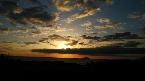 una puesta de sol sobre el océano con el sol en el cielo en Guest House Ishitatu, en Shimoda