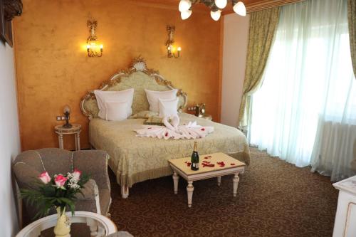 a bedroom with a bed and a table with a bottle of champagne at Pensiunea Milexim in Cîmpia Turzii