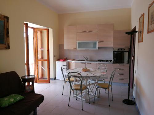 una cucina con tavolo e sedie in una stanza di Grazioso appartamento in San Marco ai Monti a San Nicola Manfredi