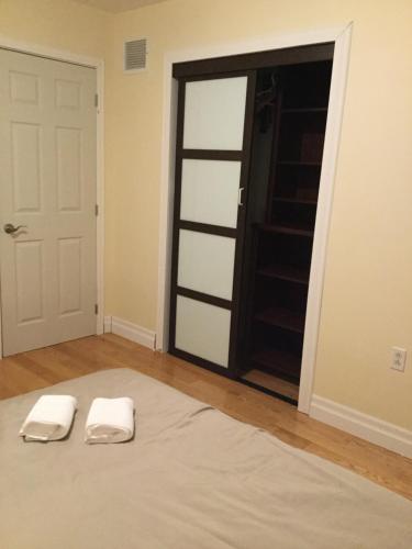 two white towels sitting on a bed in front of a door at Dairy Homestay in Toronto