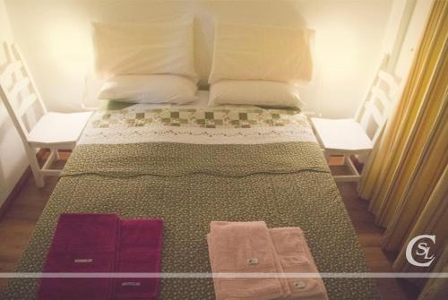 a bed with two pillows and towels on it at Cabañeros San Luis in San Roque