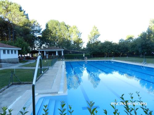 La Escapada ( Casa Rural de Gredos ) في Villarejo del Valle: مسبح بمياه زرقاء في حديقة
