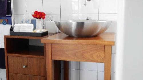 y baño con lavabo sobre una mesa de madera. en Top Floor Bed and Breakfast, en Paraparaumu Beach