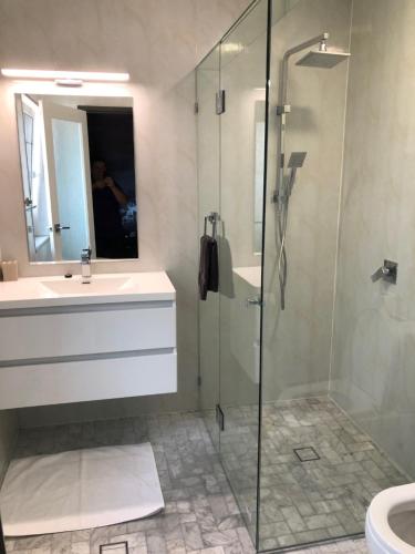 
a bathroom with a shower, sink, and toilet at Amelia Boutique Hotel in Brisbane
