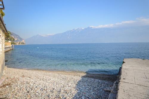 a rocky beach with a large body of water at Ex dimora di Lawrence in Gargnano