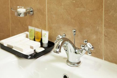 迪拜Al Waleed Holiday Homes的浴室水槽配有水龙头和肥皂盘