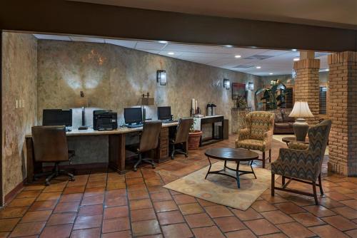 a lobby with a desk with chairs and a table at Stevens Inn a Howard Johnson by Wyndham in Carlsbad