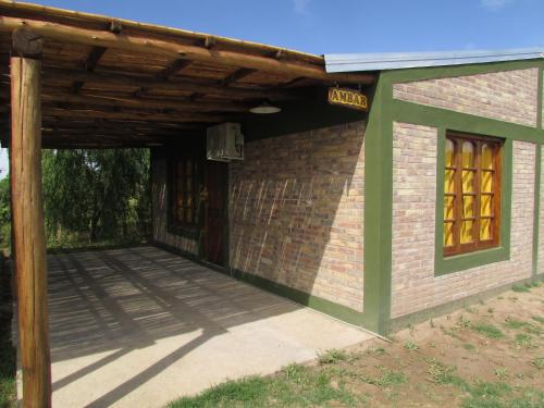 a brick building with a wooden roof and a patio at Cabañas Las Bahienses in San Rafael