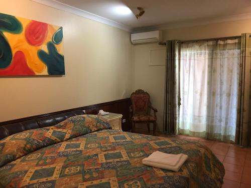 a bedroom with a bed and a painting on the wall at Heritage Resort in Weipa