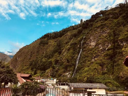 a waterfall on the side of a mountain at Hostal & Spa Casa Real in Baños