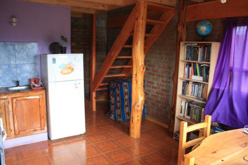 a kitchen with a refrigerator and a book shelf at Los Tres Picos in Cholila