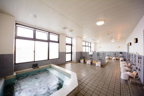 ein großes Badezimmer mit einer großen Badewanne und WCs in der Unterkunft Kochi Prince Hotel in Kōchi