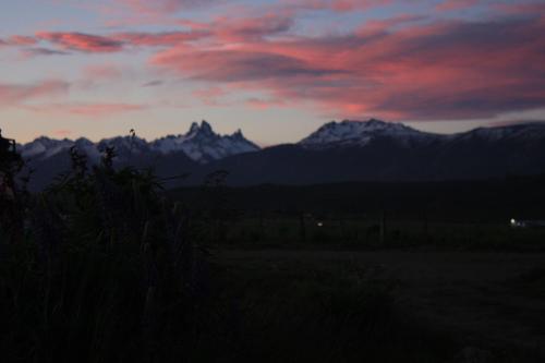 una puesta de sol con una cordillera en el fondo en Los Tres Picos en Cholila