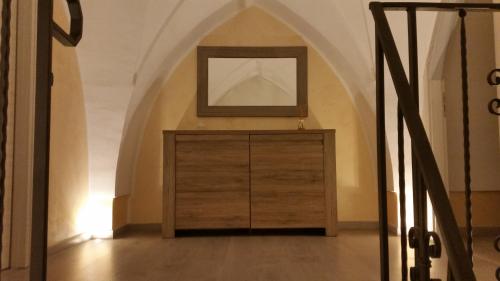 a wooden dresser in a room with an archway at La nassa fitta camere in Brindisi