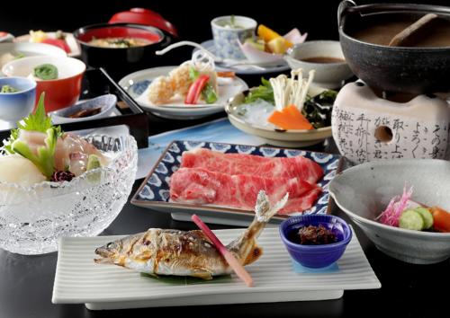 uma mesa com pratos e tigelas de comida em Usyounoie Sugiyama em Gifu