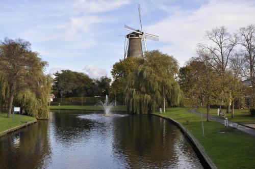 a windmill and a pond with a fountain at Hotel Mayflower in Leiden