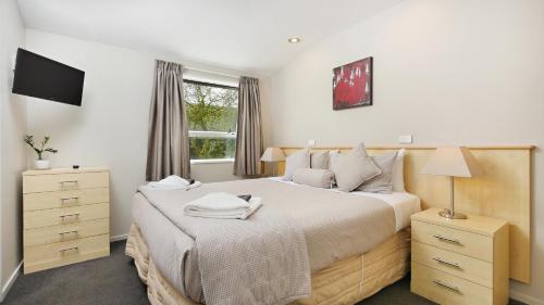 ein Schlafzimmer mit einem großen Bett und einem Fenster in der Unterkunft Arthur's Court Motor Lodge in Christchurch