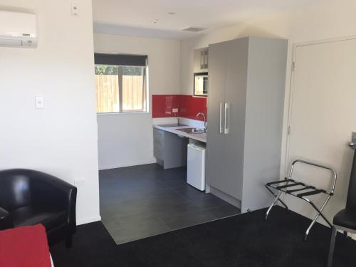 a kitchen with red and white cabinets and a black floor at Rolleston Highway Motel in Rolleston