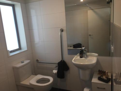 a small bathroom with a toilet and a sink at Rolleston Highway Motel in Rolleston