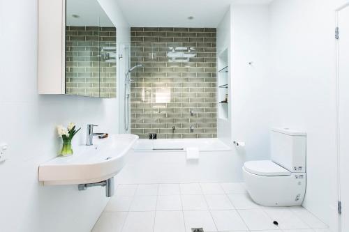 シドニーにあるコカトゥー アイランド アコモデーションの洗面台とトイレを備えた白いバスルーム