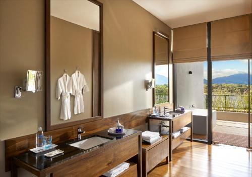 a bathroom with two sinks and a large mirror at Jetwing Lake in Dambulla