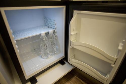 an open refrigerator with two bottles of water in it at The Southern Boutique Hotel in George Town