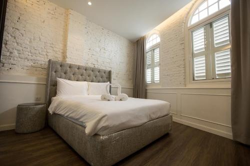 乔治市南方精品酒店的一间卧室,配有一张带两个泰迪熊的床