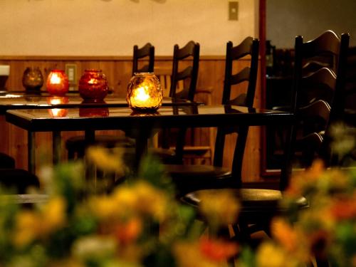 a table with candles on it with chairs and flowers at Kagura White Horse Inn in Yuzawa