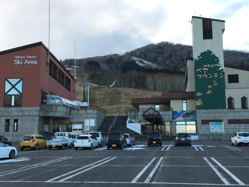 a parking lot with cars parked in front of buildings at Santari in Shintoku