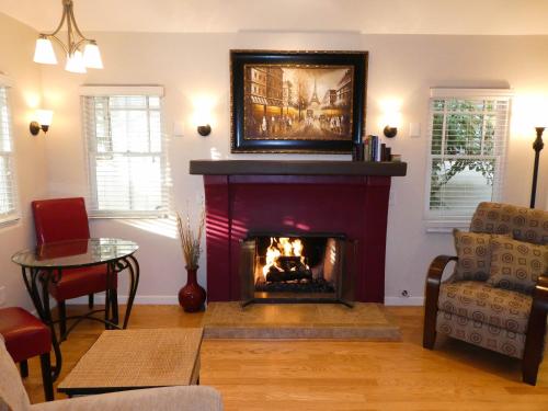 a living room with a fireplace with a painting on the wall at Briarwood Inn in Carmel