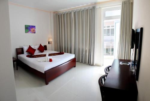 a bedroom with a bed and a large window at 1001 Nights Hotel in Mui Ne