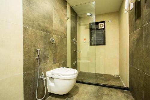 a bathroom with a toilet and a shower at Hotel Malisca in Siliguri